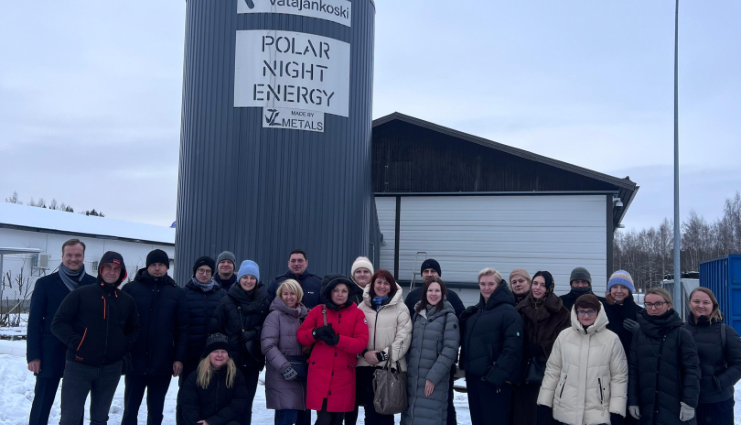 daudz cilvēku stāv pie ēkas ziemā