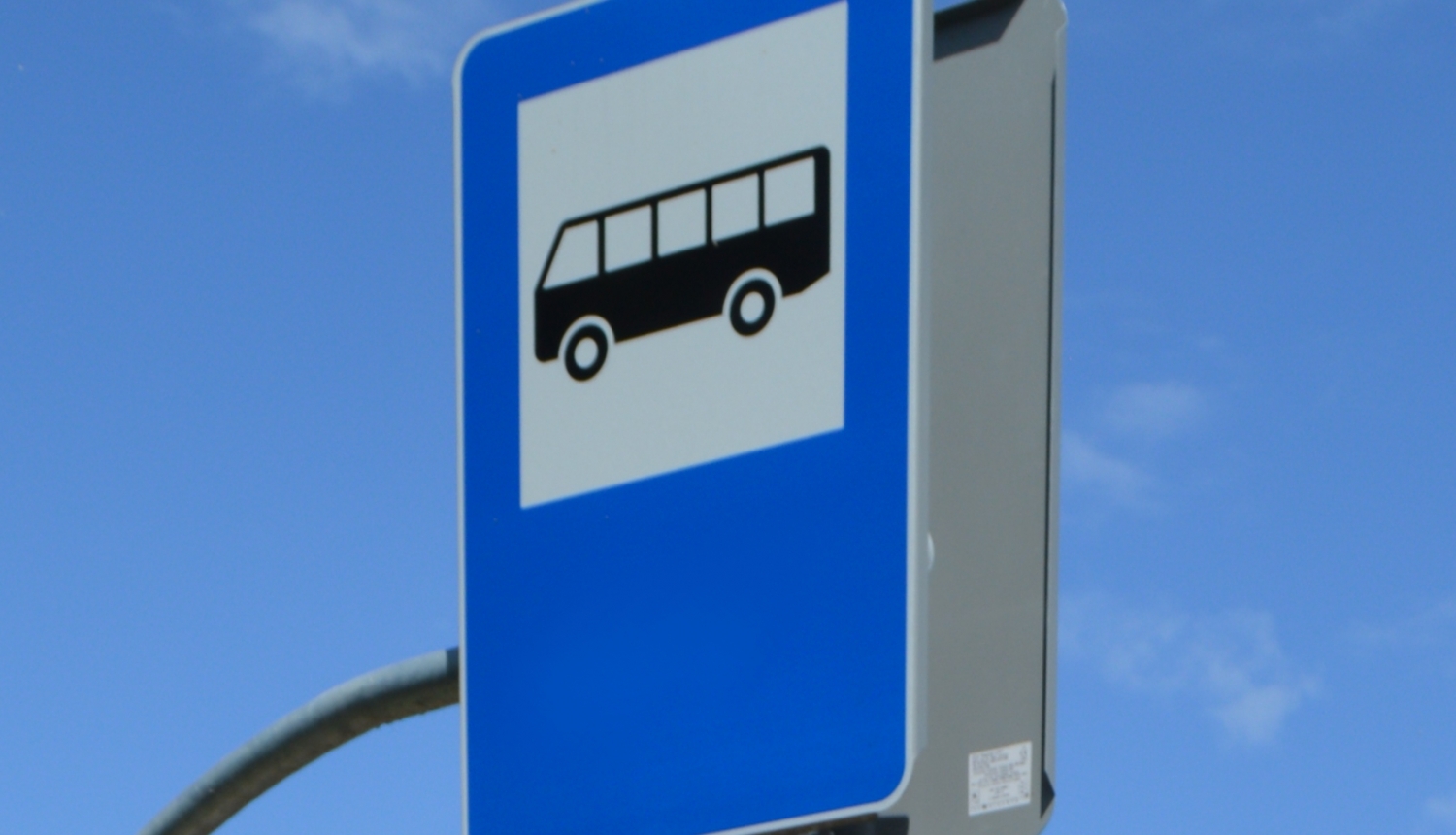 Autobusa pieturas zīme uz debesu fona