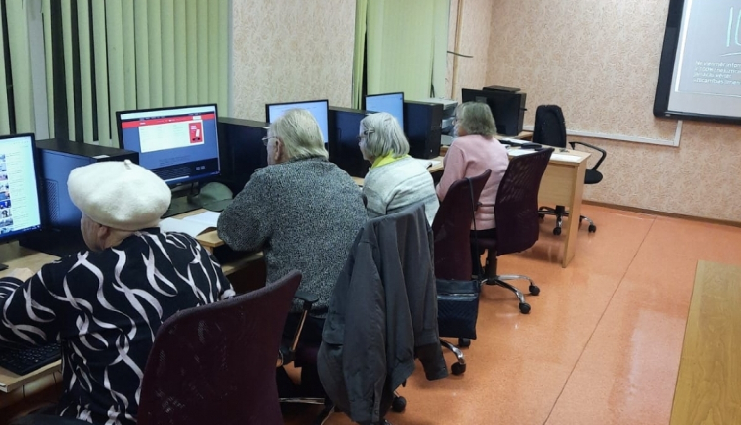veci cilvēki sēž pie datoriem