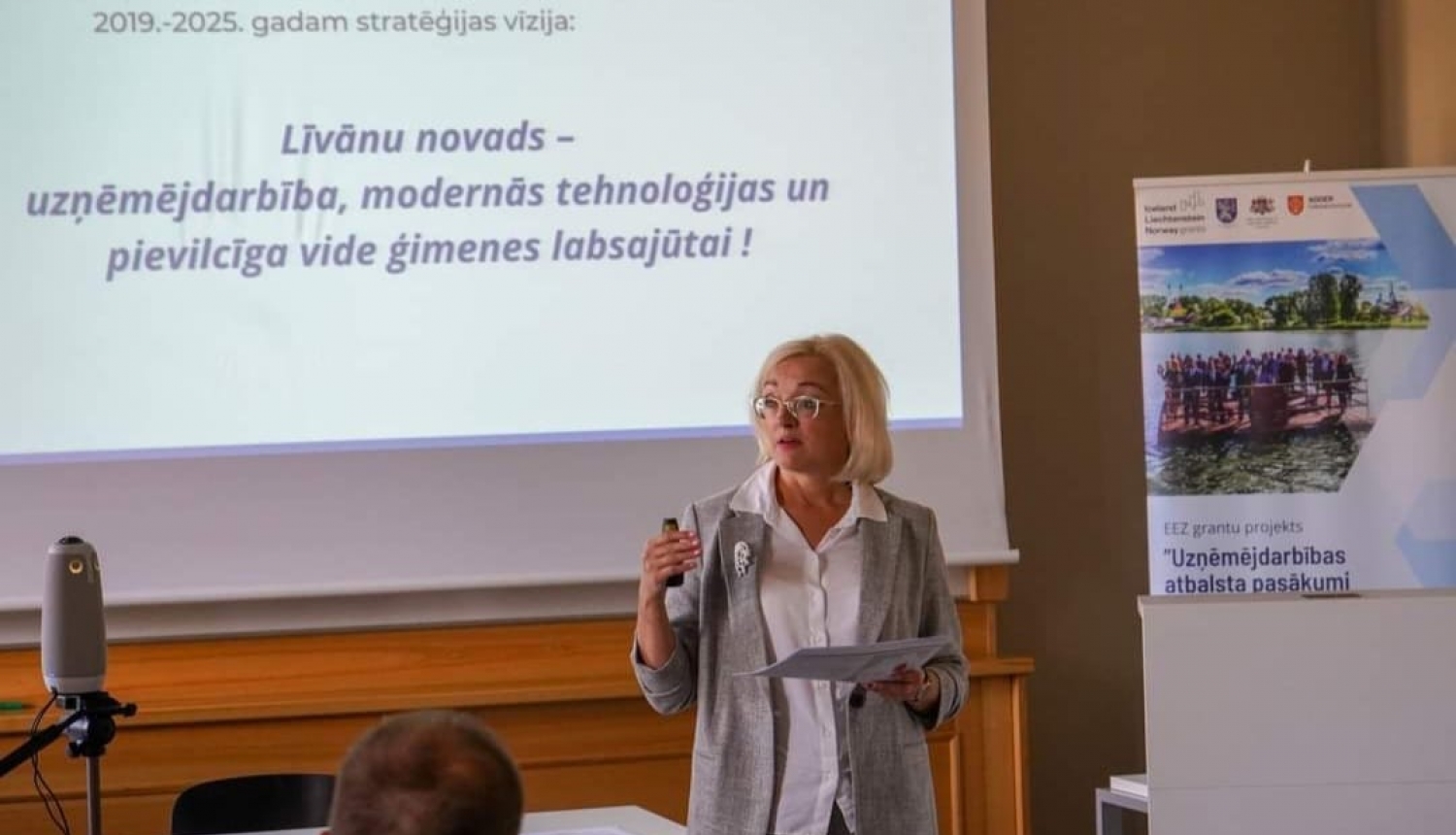 sieviete uzstājas pie prezentācijas