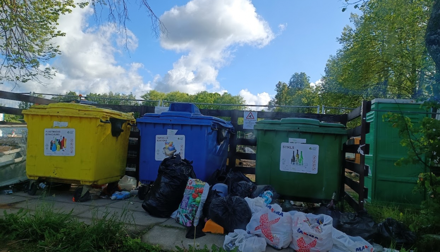 Atkritumu konteineri un samēslota apkārtne