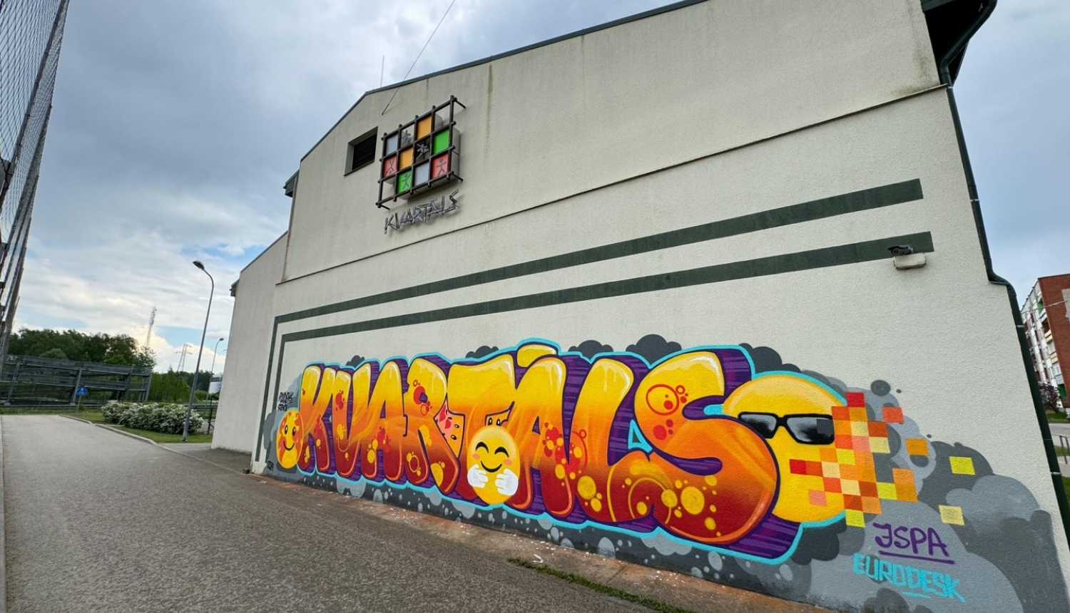 dzeltens grafiti uz mājas sienas